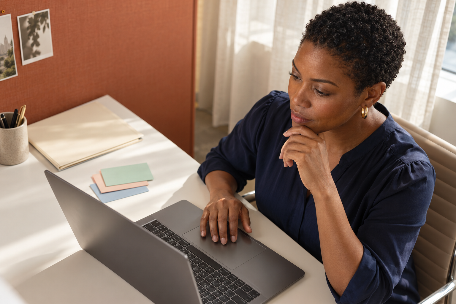 Workforce planner considering blank planning cards beside a laptop